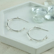Large silver hoop earrings with 7 silver balls on each hoop. They're made of eco silver and are all handmade.