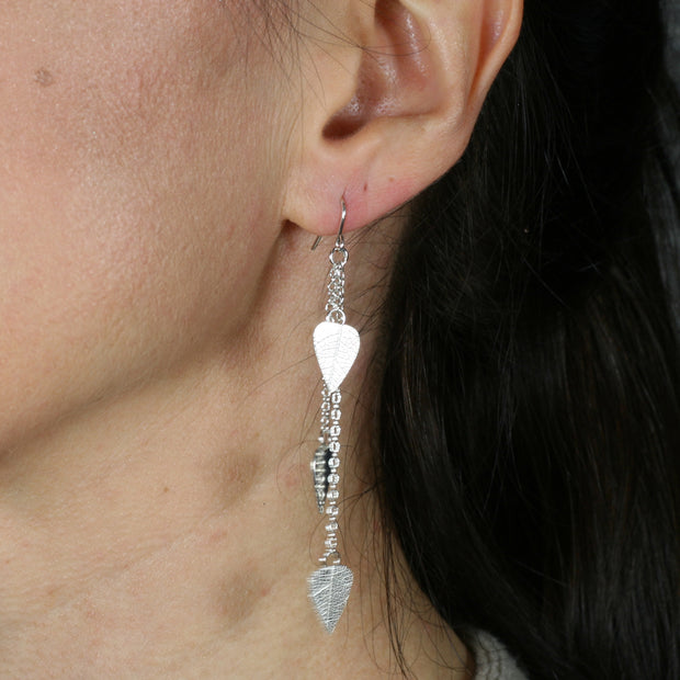 Eco silver leaves drop earings featuring three small leaves at different lengths dropped from a hook earring. The front has a real leaf texture and the back has a mirror finish. The eaf texture lets the leaves sparkle and shimmer in any light.