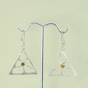 Silver triangle earrings featuring a psychedelic flower shape which has ben sawn out by hand. The heart of the flower features a Citrine gemstone in a tube setting. The silver has a hammered texture and a shiny finish.