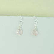 Silver briolette earrings featuring Rose Quartz faceted teardrop gemstones. The facets point at different angles catching the light perfectly for a bit shimmer and shine. They are wrapped with eco silver wire and dangle from silver earrings hooks.