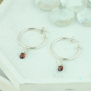 Silver hoop earrings with briolette gemstones. Classic hoop earrings, featuring a shiny polished finish. Featured here with Garnet briolette gemstones.