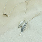 Eco silver necklace featuring two different sized leaves which have given a real leaf texture. The smaller leaf sits a little in front of the larger leaf. The back of the leaves have a shiny mirror finish.