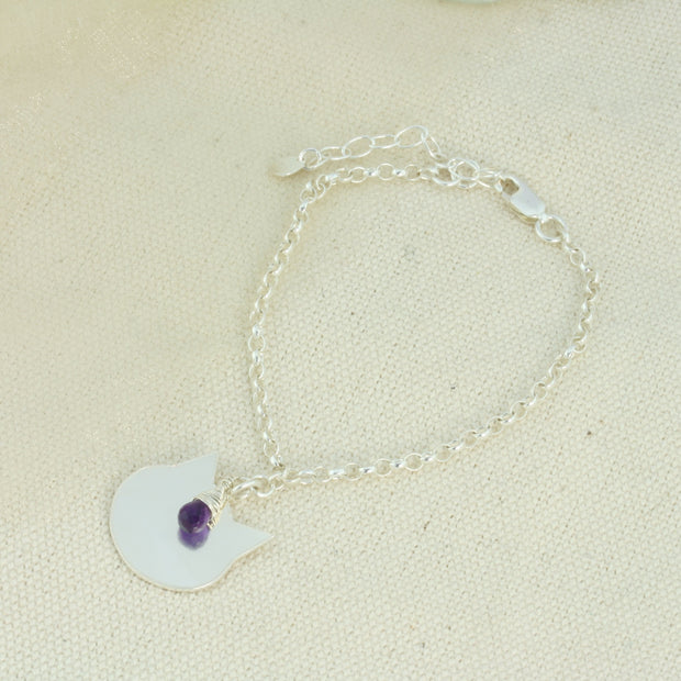 Silver personalised charm bracelet with a cat charm that can be personalised with a word, name, initials or symbols of your choosing. The bracelet features an extender chain so the bracelet fits between 16.5 and 21cm. The charm is made using eco silver. This particular bracelet also features an Amethyst briolette gemstone.