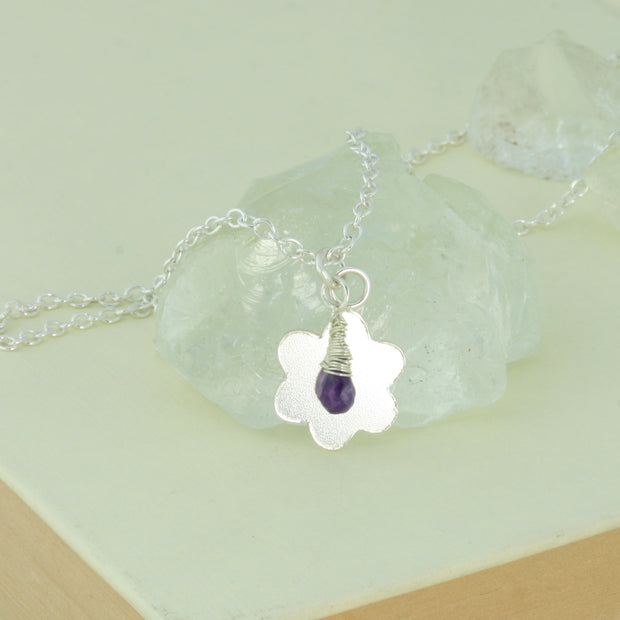 Silver personalised flower pendant necklace with Amethyst briolette gemstone.  The flower is approximately 1.5cm in diameter and can be personalised with a word, initials, letter or symbols. The briolette gemstones is attached to the same jump ring as the pendant, so they sit together. The necklace can be fastened at three different lengths at 40cm, 45cm and 50cm.