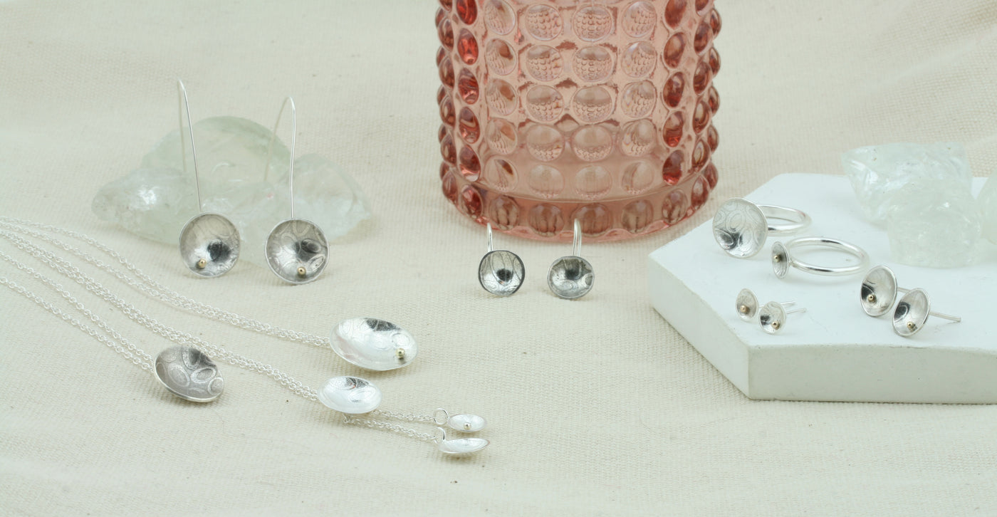 The summer cup collection, featuring domed cups with a pebble or striped texture on the inside of the cup and the option of a 9ct gold ball added to the cup. Earrings, rings, necklaces and a bracelet are all available. 