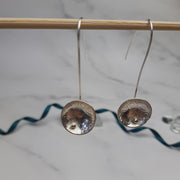 Eco silver drop cup earrings with 9ct gold ball. The drop hook and cup are made from eco silver. The cup has been given a pebble texture and a mirror finish. The gold ball sits in the bottom half of the cup.