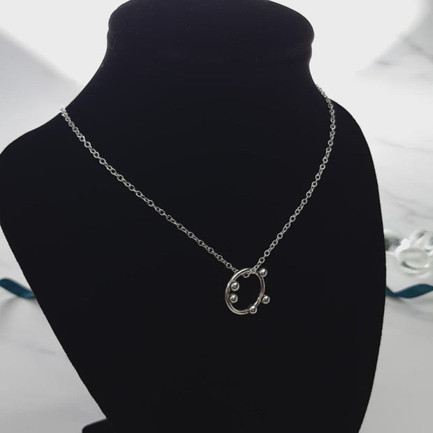 Silver hoop pendant necklace with 5 silver balls. The pendant is made from eco silver and the necklace can be fastened at two different lengths with a lobster clasp.