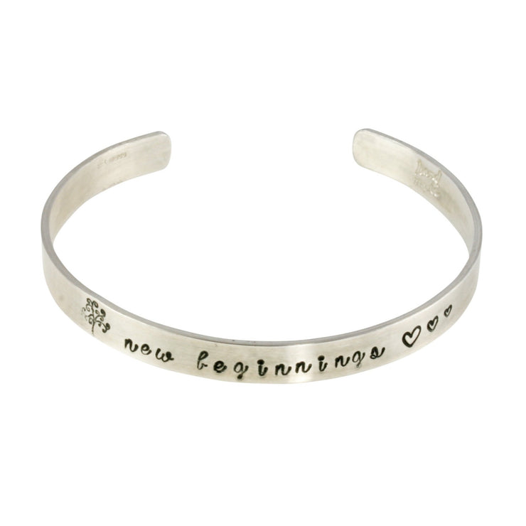 Silver personalised bangle. This bangle bracelet features a Tree of life stamp and three hearts with &