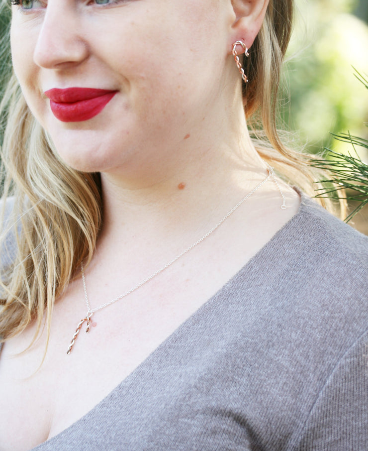 Silver and copper pendant necklace featuring a candy cane shape made from copper and silver wire that has been twisted around each other. Available in two sizes and seen here with the matching stud earrings.