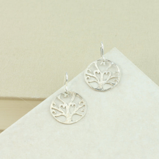 Silver hook earrings earrings with a Tree of life symbol. It is a unqie handmade design and has a hammered texture and mirror finish.