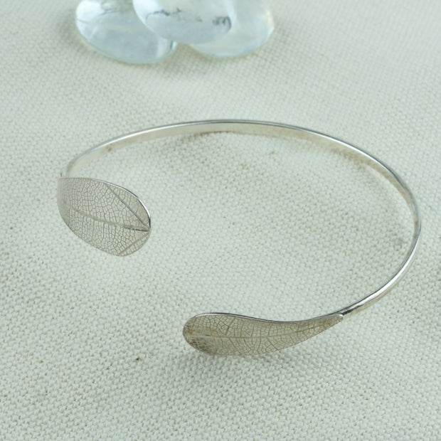 Eco silver bangle bracelet with a leaf on both ends of the bangle. They curve along with te bangle and have a realistic leaf texture. The mirror finish lets this bangle sparkle and shine.