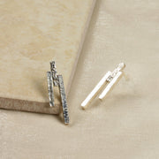 Eco silver stud earrings featuring three bars with different lenghts and textures. They have been placed at different heights.