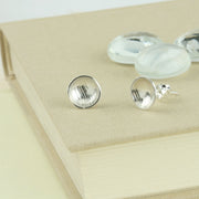 Eco silver cups studs with a stripe texture.  The earrings have a shiny finish.