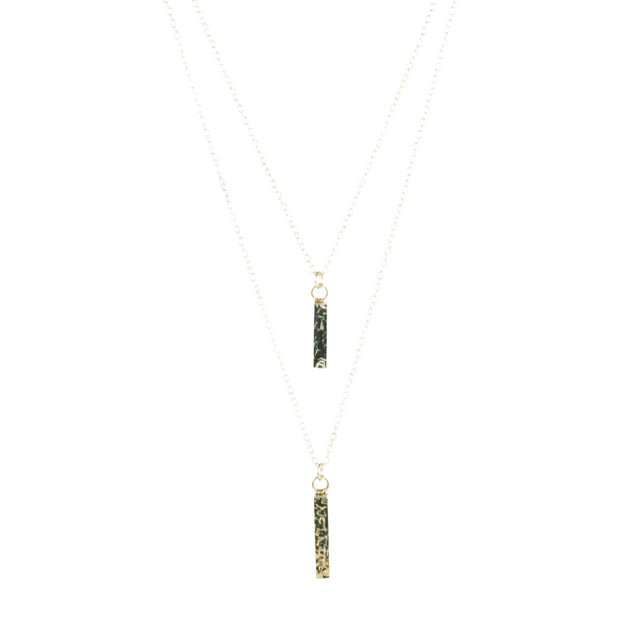 Eco silver pendant necklace featuring two bars. Both have a square hammered texture and shiny mirror finish. They are attached to two chain with different lengths letting one bar sitting above the other.