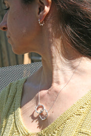 Silver necklace featuring two hoops, one larger and one smaller hoop. With 5 silver balls on the smaller hoop and 6 silver balls on the larger hoop. The silver trace chain is attached to both hoops and fastens with a lobster clasp. The necklace is 45 cm / 18" long. Combined with the small hoop and balls earrings.