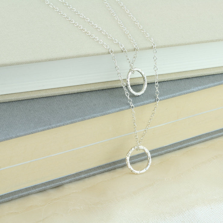Silver double hoop multi strand necklace. Both hoops have a hammered shiny finish to let the light bounce of and give them a sparkly finish.