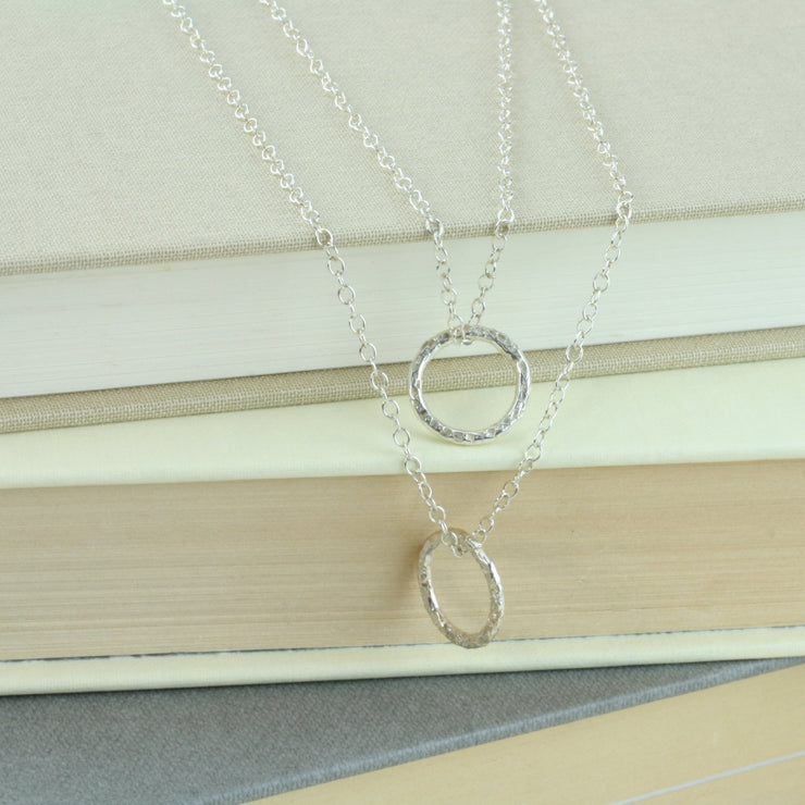 Silver double hoop multi strand necklace. Both hoops have a hammered shiny finish to let the light bounce of and give them a sparkly finish.