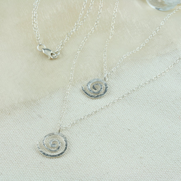 Silver multi strand swirl necklace. Two swirls feature this necklace with two strands. The swirls have a hammered shiny finish and fasten with a lobster clasp.