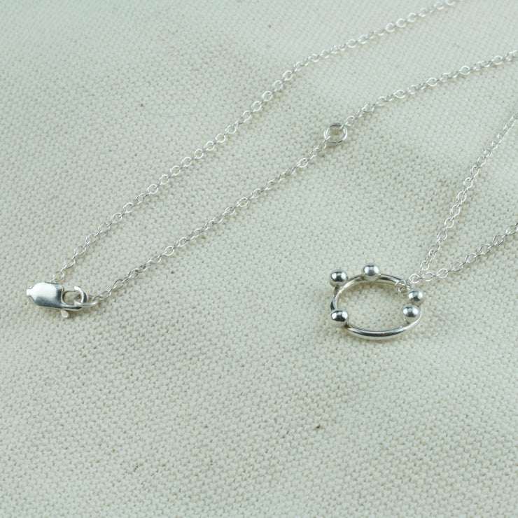 Silver hoop pendant necklace with 5 silver balls. The pendant is made from eco silver and the necklace can be fastened at two different lengths with a lobster clasp.