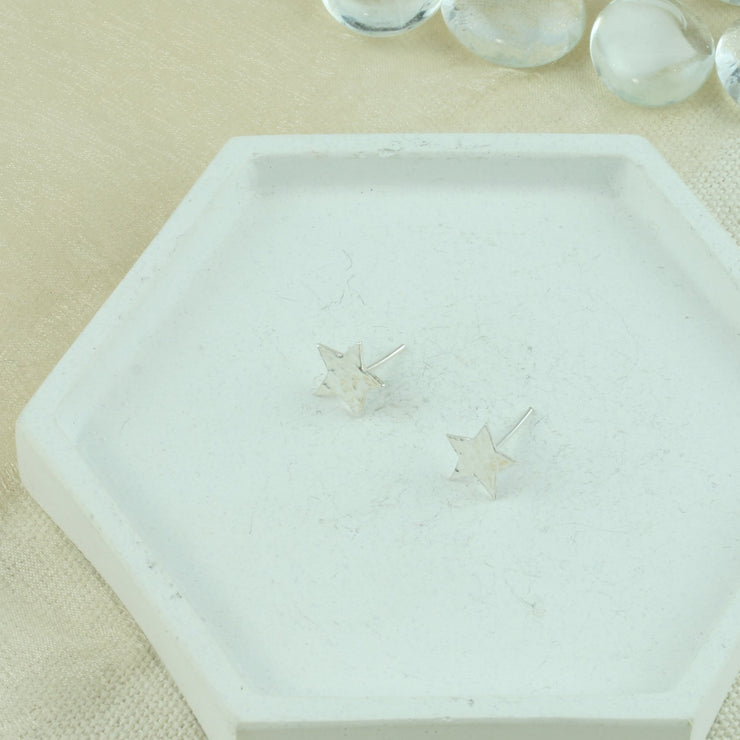 Eco silver stud earrings in the shape of a five pointed star. They have a round hammered shiny finish.