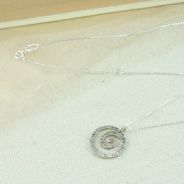 Silver swirl pendant with a hammered texture to add sparkle to it. The necklace is a hammered trace chain.