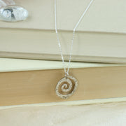 Silver swirl pendant with a hammered texture to add sparkle to it. The necklace is a hammered trace chain.