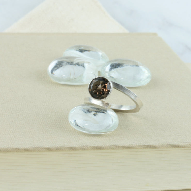 Eco silver twisted ring with Smoky Quartz gemstone. A square ring band twisted to sit comfortably around the finger and hold the gemstone. The setting is a collet setting which holds the gemstone in place about 10mm higher above the ring band.