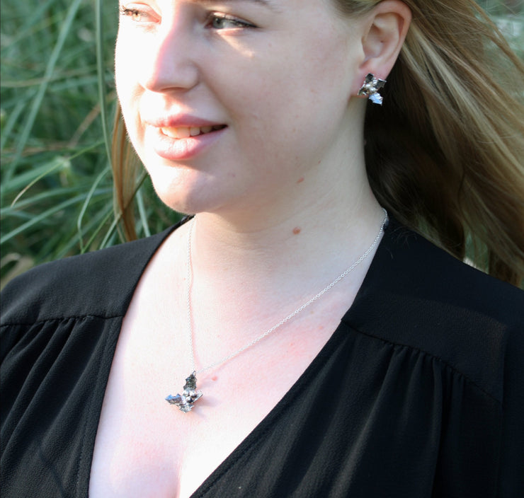 Set of the Silver holly pendant necklace and Silver holly stud earrings. All featuring holly with four leaves with a hammered texture and aged darker finish, polished to a shine. And three shiny silver berries in the centre.