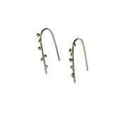 Silver earrings made from silver wire that hooks through the ear. Three silver and three 9ct gold balls are attached to the front of the earrings. They have a shiny mirror finish.