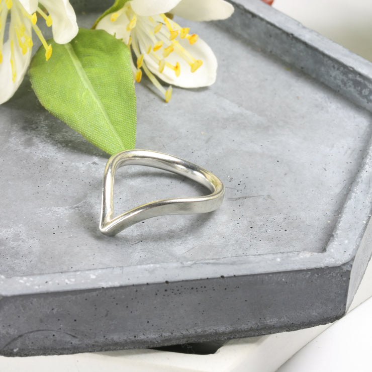 Eco silver wishbone ring. This ring is made using D shaped wire with the curve on the inside and the flat side on the outside. The rich dips into a V-shape on one side. This  design is beautiful on its own and in combination with a gemstone ring allowing space to wrap around it.