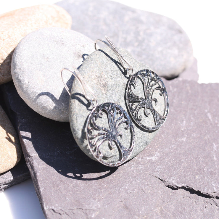 Eco silver Tree of life hook earrings. The Tree of life hangs from a 20mm hook. Both the front of the hook and the Tree of life have a hammered and oxidised darker finish. Full of symbolism for new beginnings and growth.