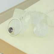 Silver pendant necklace featuring a hoop with a gemstone in inside at the bottom. The gemstone measures 8mm in diameter. This pendant features an Amethyst Rose cut cabochon gemstone, other options are available.