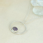 Silver pendant necklace featuring a hoop with a gemstone in inside at the bottom. The gemstone measures 8mm in diameter. This pendant features an Amethyst Rose cut cabochon gemstone, other options are available.