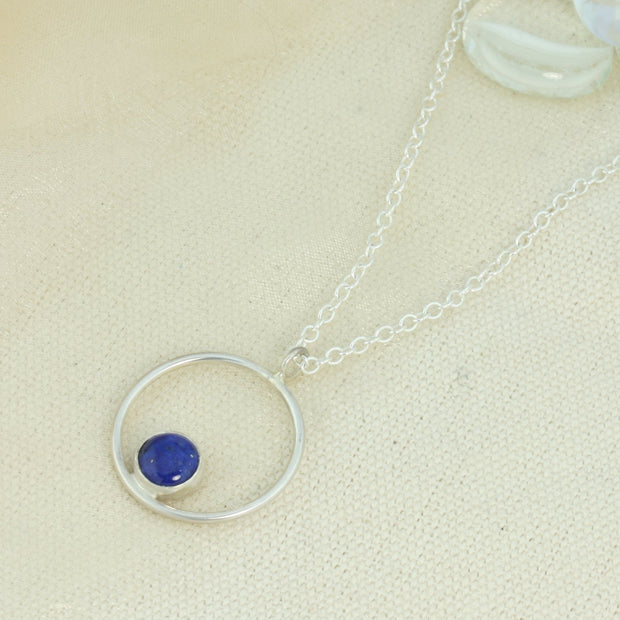 Silver pendant necklace featuring a hoop with a gemstone in inside at the bottom. The gemstone measures 8mm in diameter. This pendant features a Lapis Lazul gemstone, other options are available.
