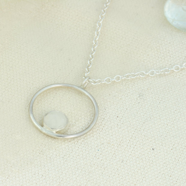 Silver pendant necklace featuring a hoop with a gemstone in inside at the bottom. The gemstone measures 8mm in diameter. This pendant features an Moonstone Rose cut cabochon gemstone, other options are available.