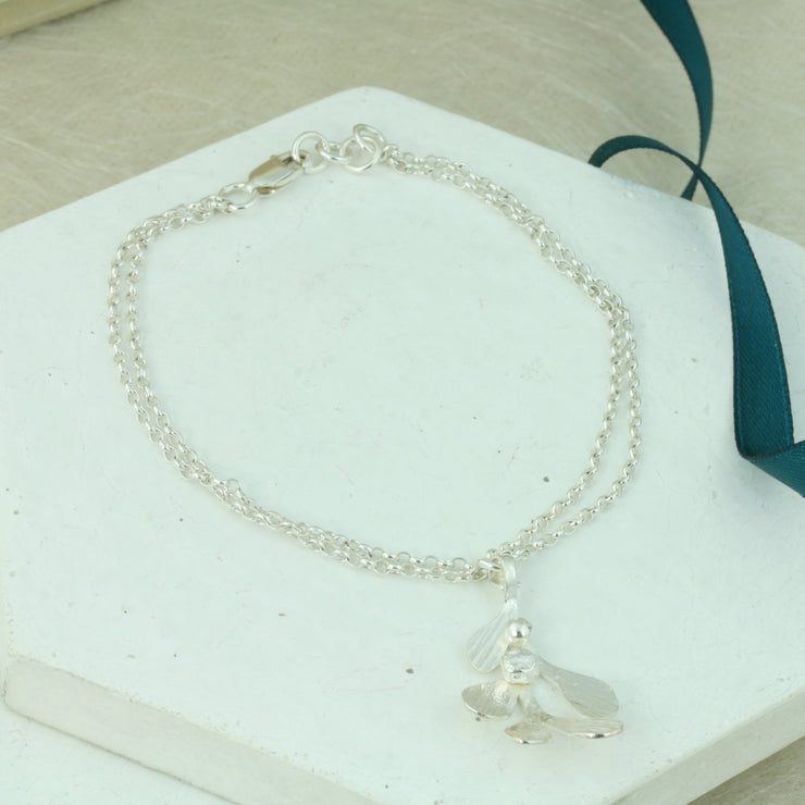 Silver chain bracelets, made with two strands of trace chain and featuring a Mistletoe charm. The charm has five leaves with a hammered shiny textured finish and two silver balls as berries. 