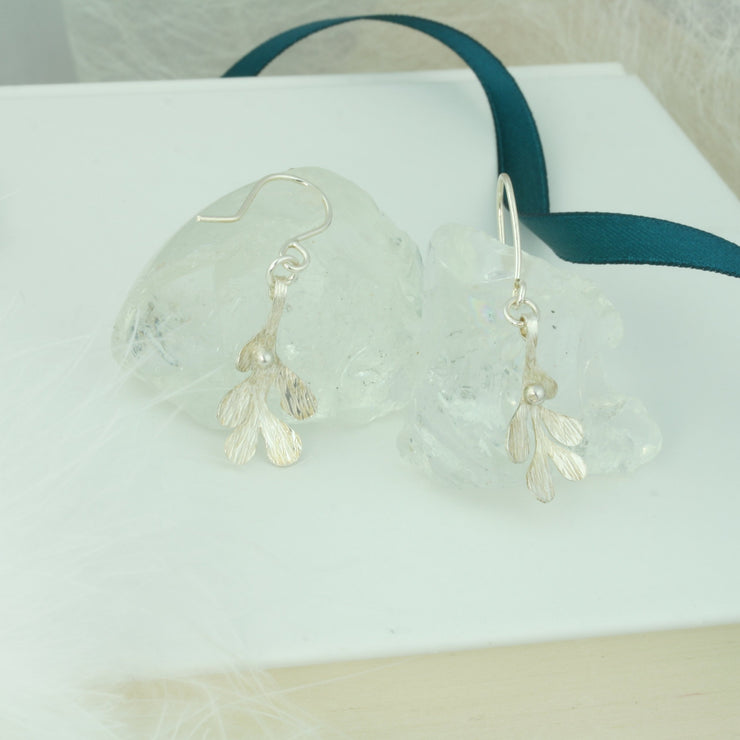 Silver hook earrings featuring Mistletoe with a silver ball as a berry. The leaves have a striped texture and a shiny silver finish. The total drop is 2.5cm from the hook.