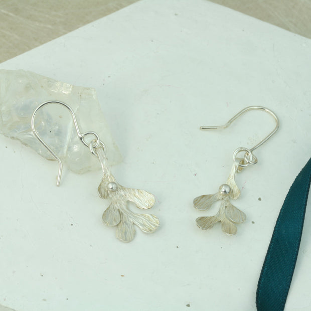 Silver hook earrings featuring Mistletoe with a silver ball as a berry. The leaves have a striped texture and a shiny silver finish. The total drop is 2.5cm from the hook.