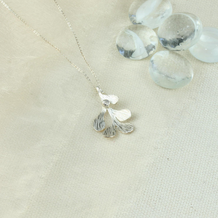 Silver Mistletoe pendant necklace. This necklace can be worn at two different lengths and features a Mistletoe pendant with five textured leaves and a silver berry at the top of the leaf.