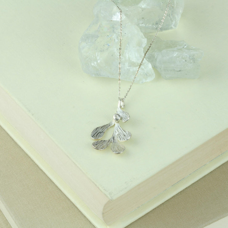 Silver Mistletoe pendant necklace. This necklace can be worn at two different lengths and features a Mistletoe pendant with five textured leaves and a silver berry at the top of the leaf.