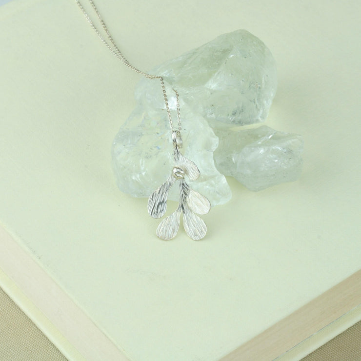 Silver Mistletoe pendant necklace. This necklace can be worn at two different lengths and features a Mistletoe pendant with five textured leaves and a silver berry at the top of the leaf.