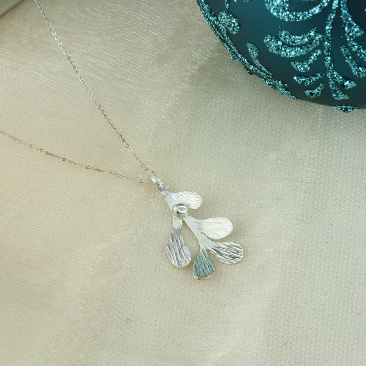 Silver Mistletoe pendant necklace. This necklace can be worn at two different lengths and features a Mistletoe pendant with five textured leaves and a silver berry at the top of the leaf.