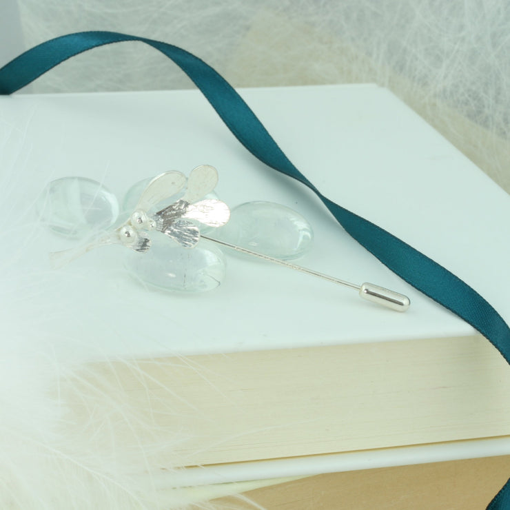 Silver pin featuring a Mistletoe shape with five small leaves and three berries at the top. It is 3.5 x 2 cm in size and the 5cm long pin at the back comes with a pin protector to pop onto the sharp end. All polished to a mirror finish, with a striped hammered texture on the front of the leaves. Lovely on a hat, scarf, or jacket.