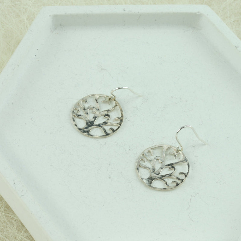 Silver hook earrings earrings with a Tree of life symbol. It is a unqie handmade design and has a hammered texture and mirror finish.