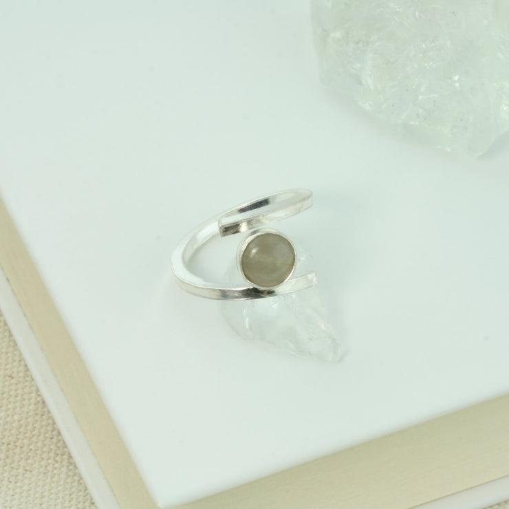 Eco silver square ring band holding a Grey Moonstone between both ends. The Moonstone is attached to the ring on one side making it adjustable and very comfortable to wear.