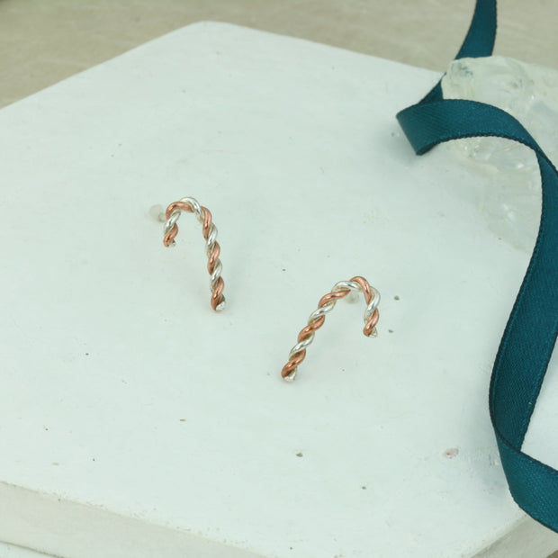 Silver and copper stud earrings. Silver and copper wire has been twisted around each other and shaped into a candy cane shape. Available in two sizes and a matching pendant necklace is also available.