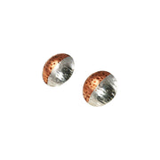 Round stud earrings with one half in copper and the other half in silver. They have been domed with the curve facing outwards. They're available with a stiped texture or a round texture and have a shiny mirror finish.