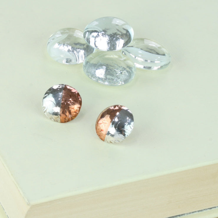 Round stud earrings with one half in copper and the other half in silver. They have been domed with the curve facing outwards. They&