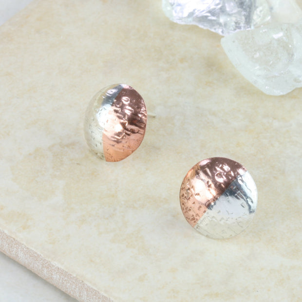 Round stud earrings with one half in copper and the other half in silver. They have been domed with the curve facing outwards. They&