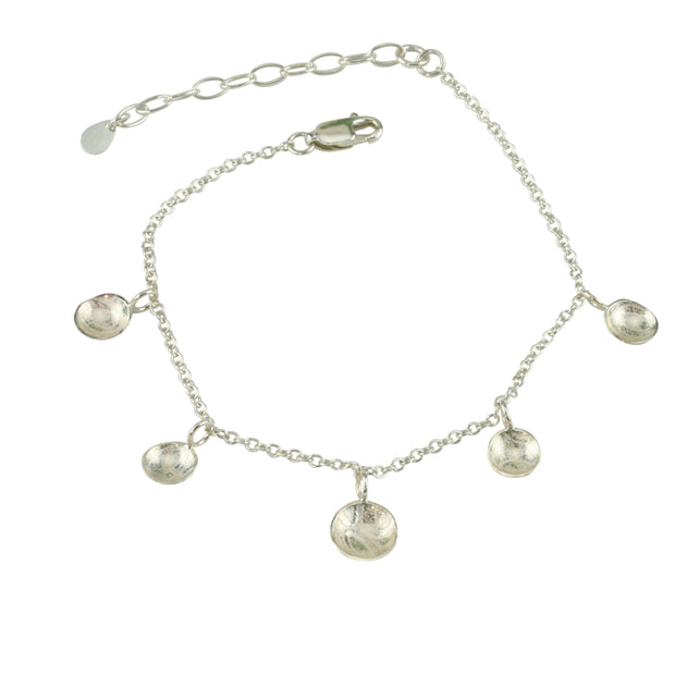 Silver bracelet featuring five domed cups. The middle cups is slightly larger than the other 4. It is fastened with a lobster clasp and can be fastened at different lengths. The cups have a pebble texture.